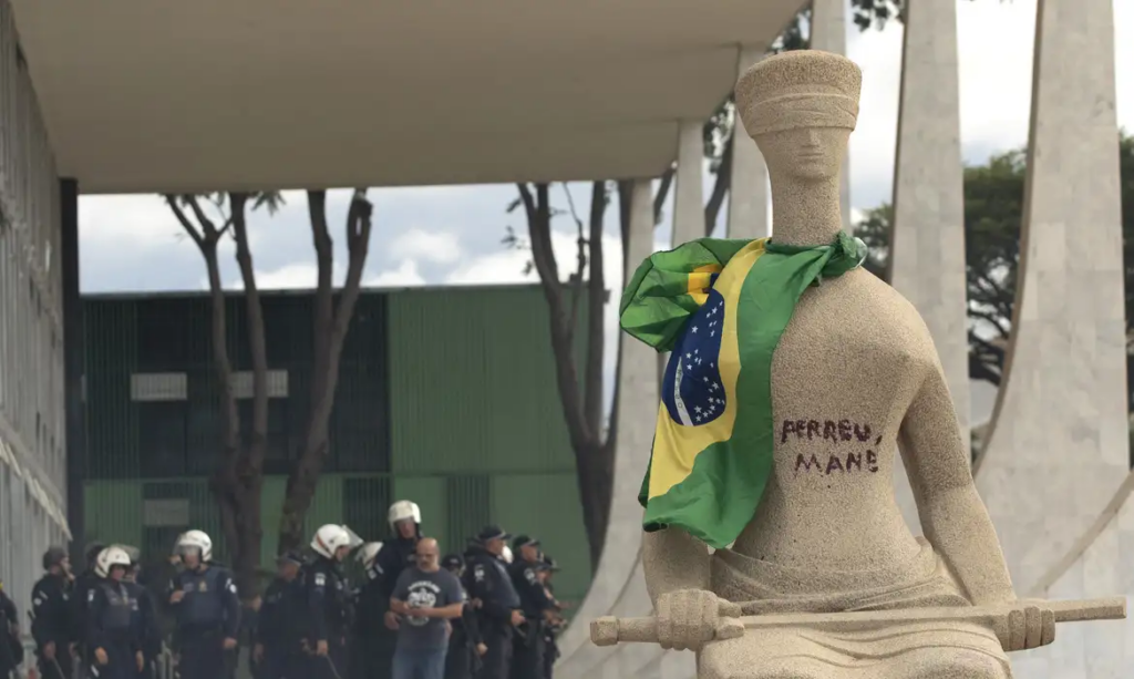 participar dos atos e pichar a frase “Perdeu, mané” na estátua A Justiça, locali
