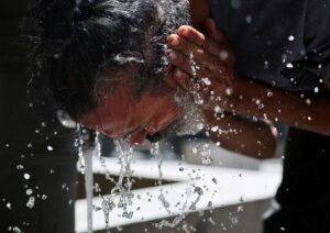 Homem lava o rosto para se refrescar durante onda de calor em Madri, na Espanha, em 23 de junho de 2026. REUTERS/Mohammed Salem