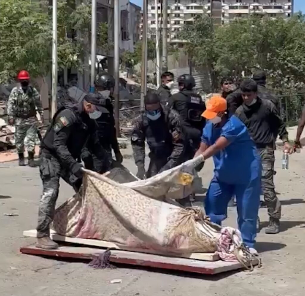 Trabalho de bombeiros e policiais na Venezuela encontra dificuldades diante do elevado número de vítimas. Na imagem, policiais jogam cal em corpo