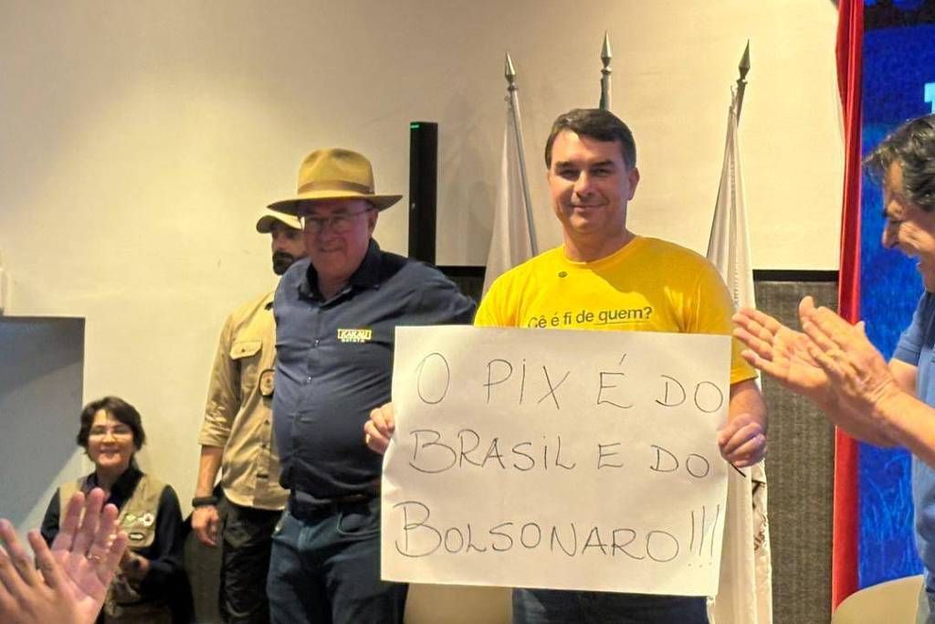Flávio Bolsonaro (PL-RJ) levanta cartaz escrito "o Pix é do Brasil e do Bolsonaro", em Contagem, Minas Gerais. Foto: reprodução / rede x