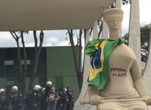 participar dos atos e pichar a frase “Perdeu, mané” na estátua A Justiça, locali