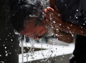 Homem lava o rosto para se refrescar durante onda de calor em Madri, na Espanha, em 23 de junho de 2026. REUTERS/Mohammed Salem