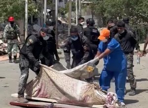 Trabalho de bombeiros e policiais na Venezuela encontra dificuldades diante do elevado número de vítimas. Na imagem, policiais jogam cal em corpo