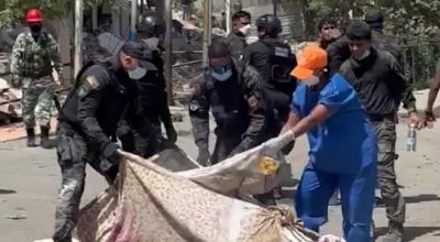 Trabalho de bombeiros e policiais na Venezuela encontra dificuldades diante do elevado número de vítimas. Na imagem, policiais jogam cal em corpo