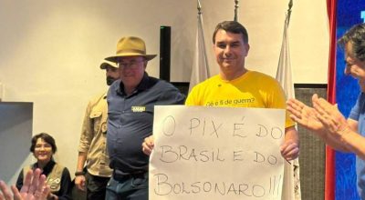 Flávio Bolsonaro (PL-RJ) levanta cartaz escrito "o Pix é do Brasil e do Bolsonaro", em Contagem, Minas Gerais. Foto: reprodução / rede x