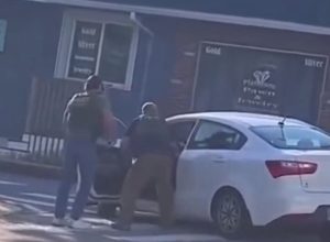 O perfil no X do Scope Report publicou vídeo dos agentes retirando o corpo de Guerrero do carro e o algemando